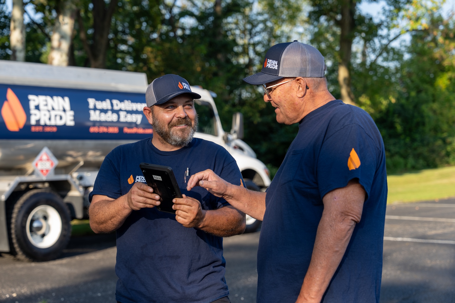 Two Penn Pride workers consult a tablet.