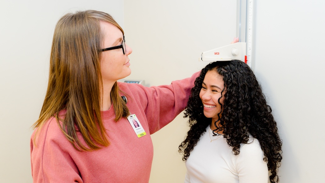 Female healthcare provider measuring height of female patient at HCHC in Harrisonburg.