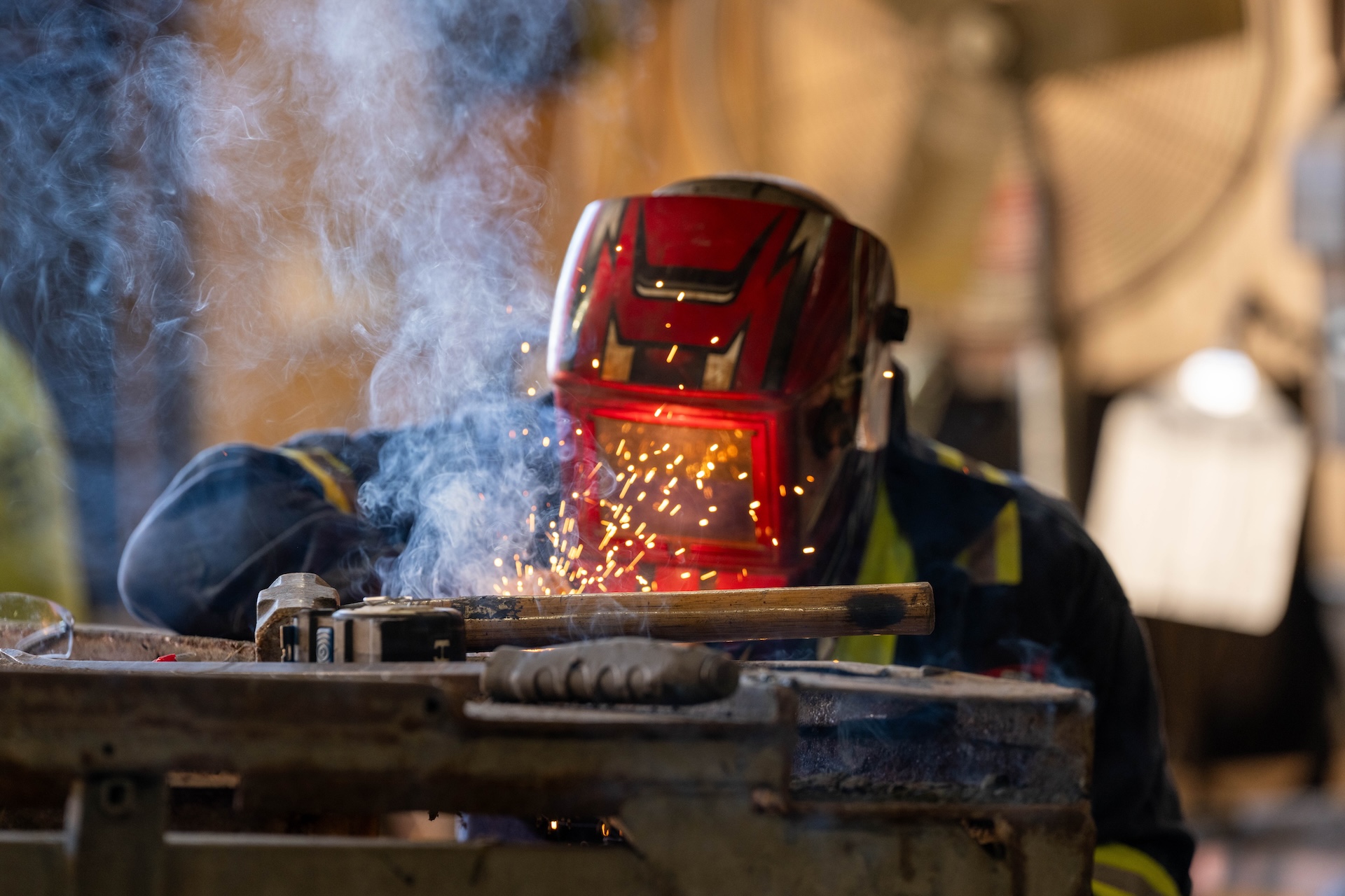 Welder with a welding helmet on working.