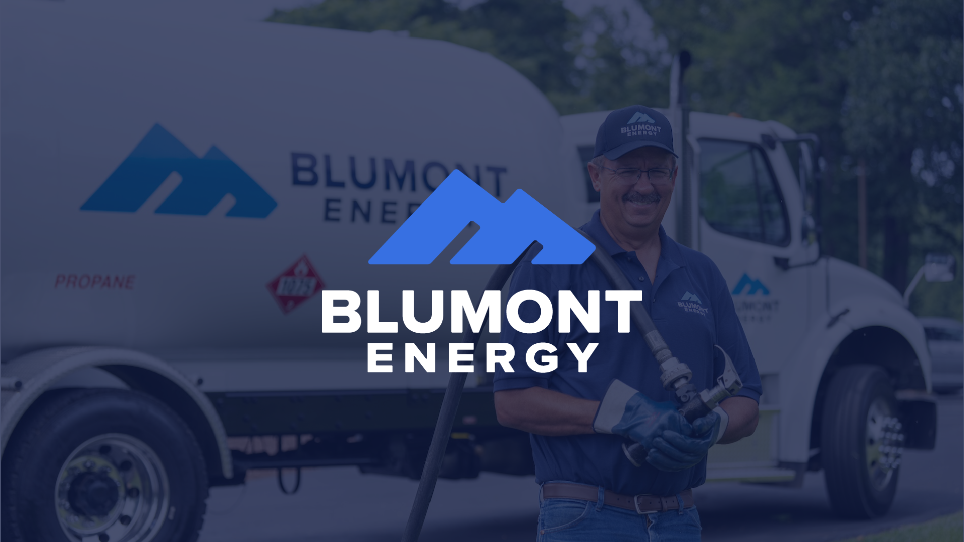 Blumont Energy logo centered over a blue transparency with Blumont Energy employee standing in front of propane tank, preparing for a propane delivery. Custom photography by Estland.