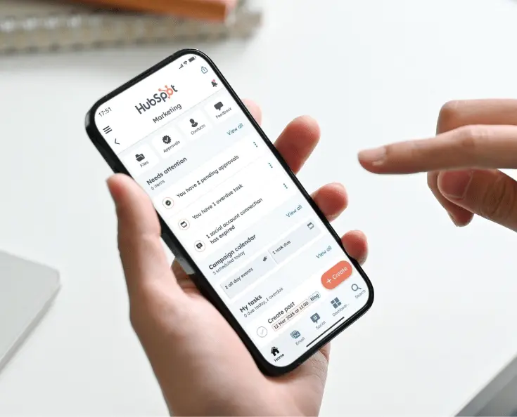 HubSpot mobile app displayed on a phone held in a user's hand.