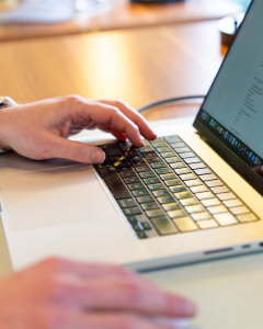 Hands working on a lap keyboard.
