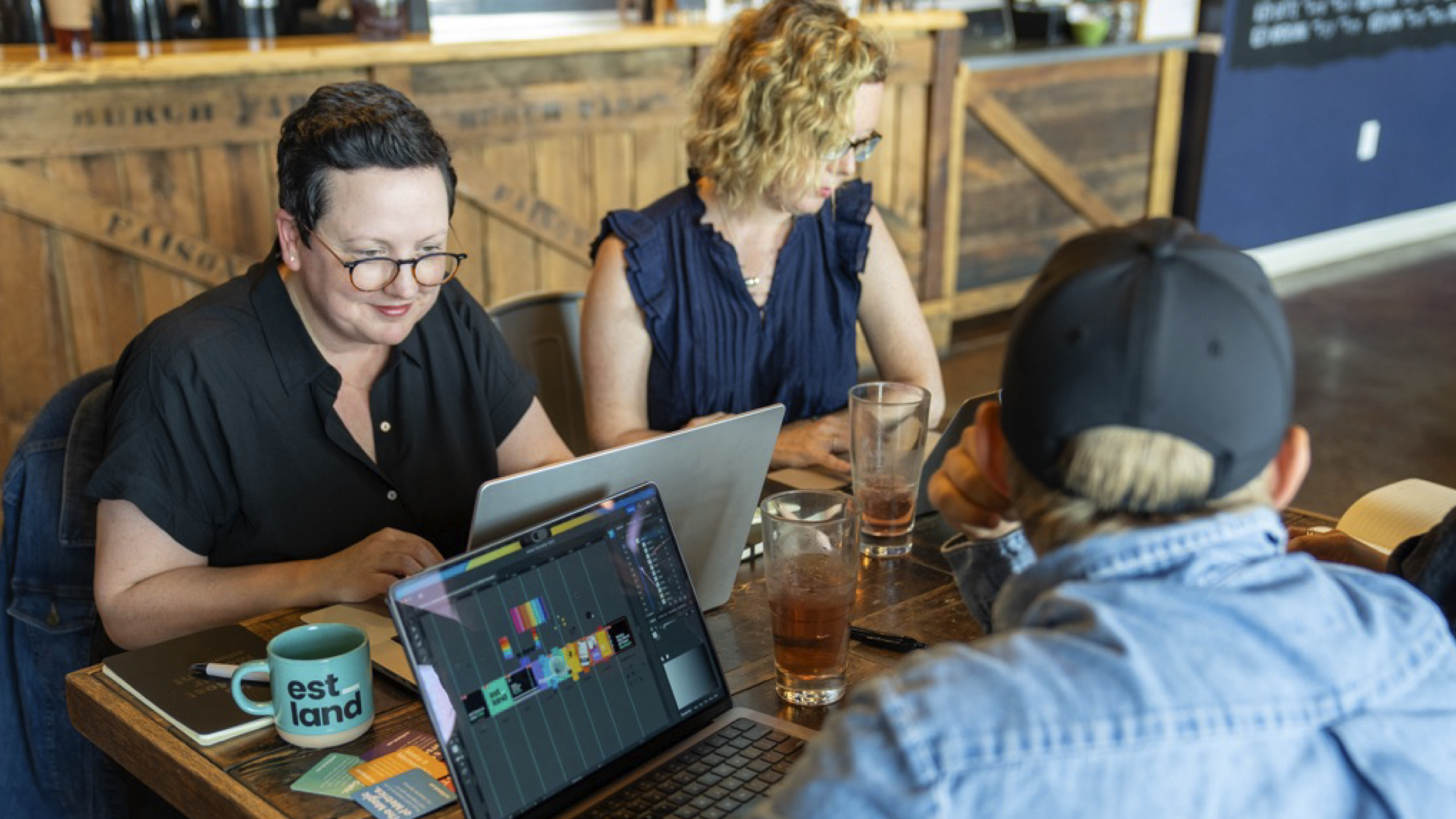 A group of people working on laptops at a table.